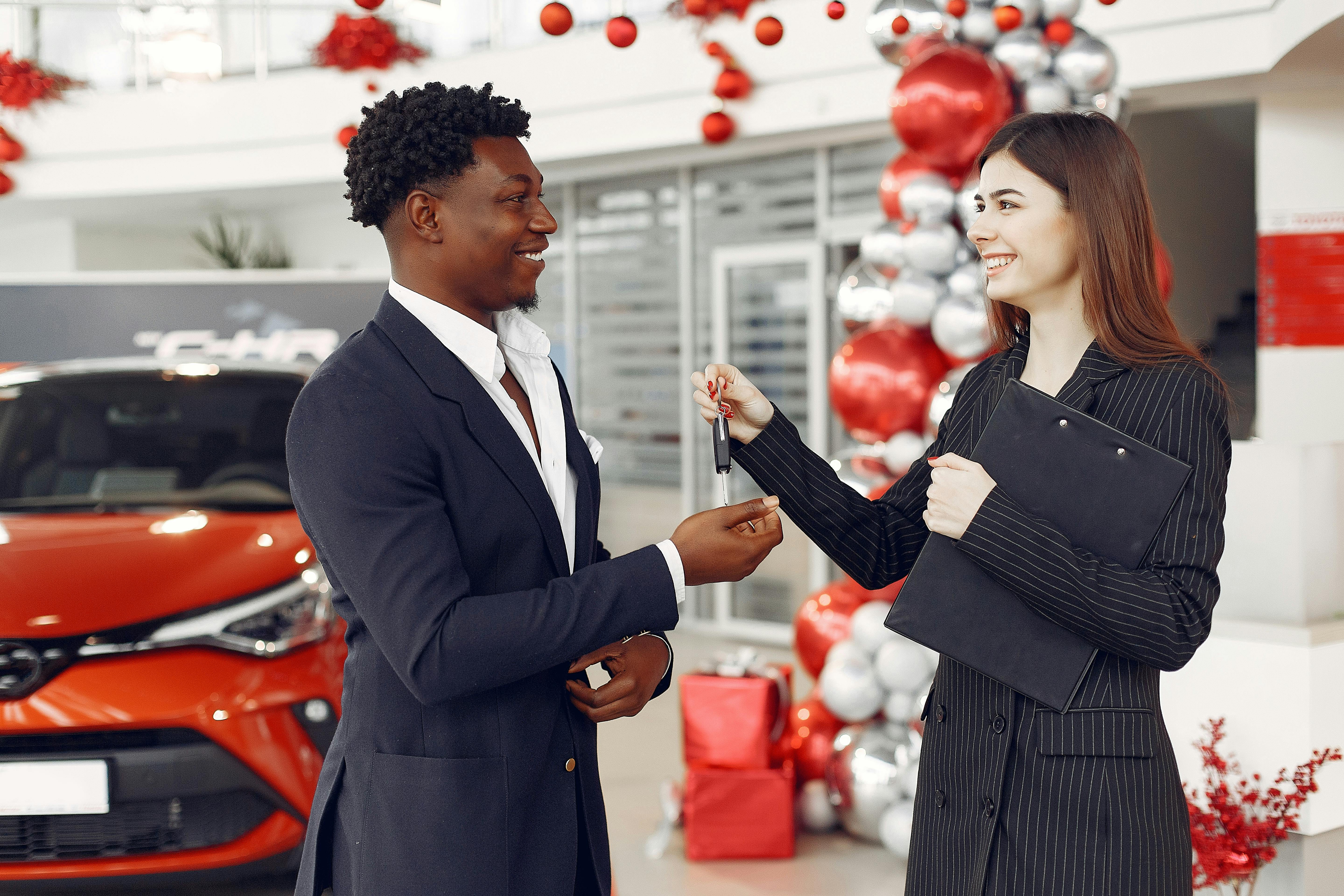 Autobedrijf dat sleutels overhandigt in een showroom